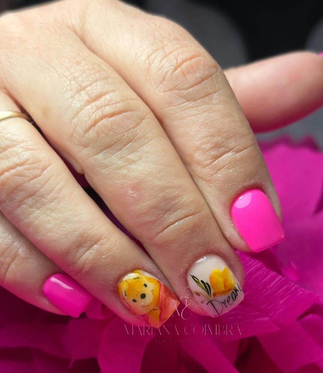 Unhas curtas em rosa vibrante com ilustração do Ursinho Puff e flor amarela com a palavra Dream