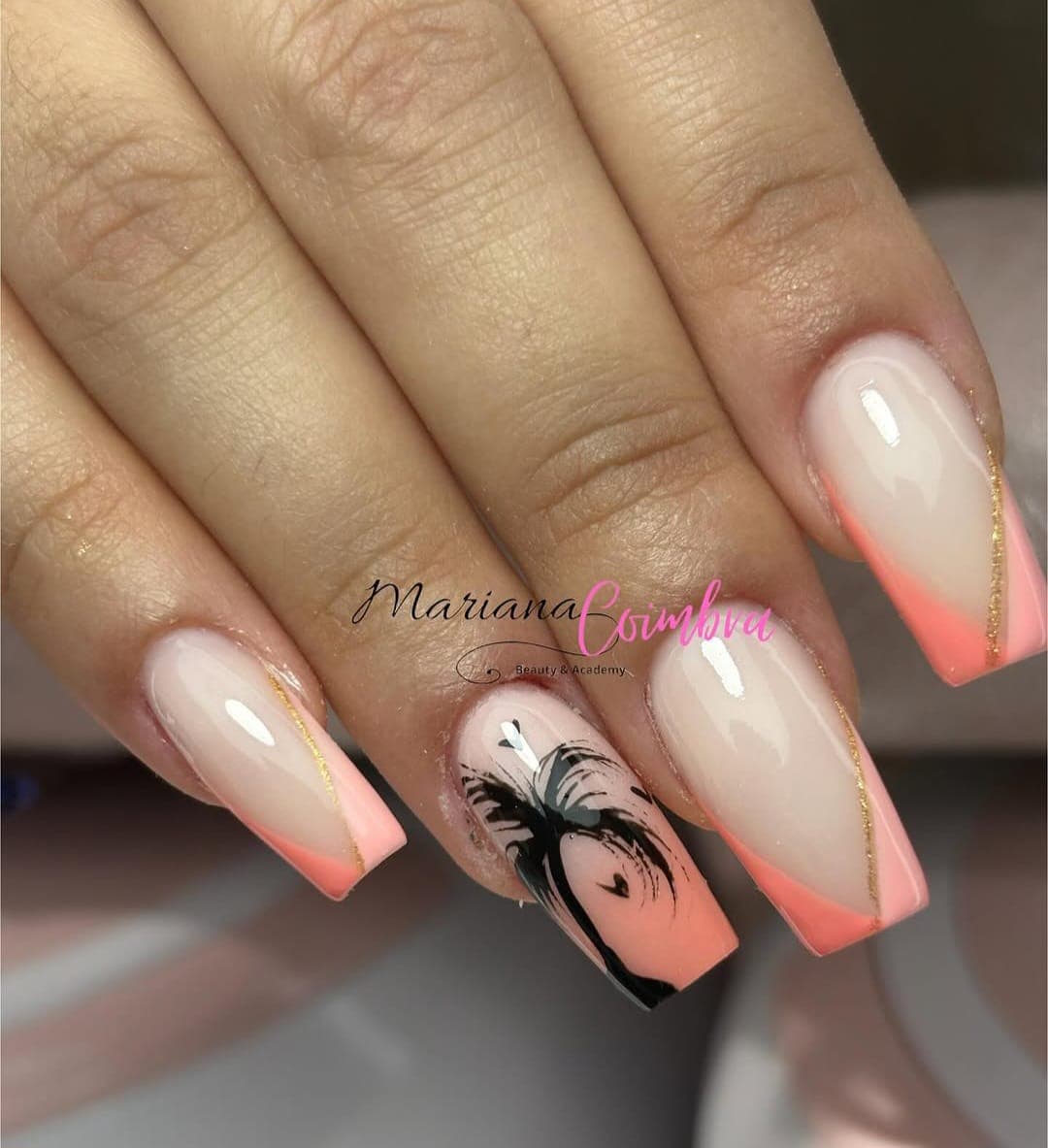Unhas quadradas compridas com ombré coral e desenho preto de folha numa unha em destaque, detalhe em fio dourado
